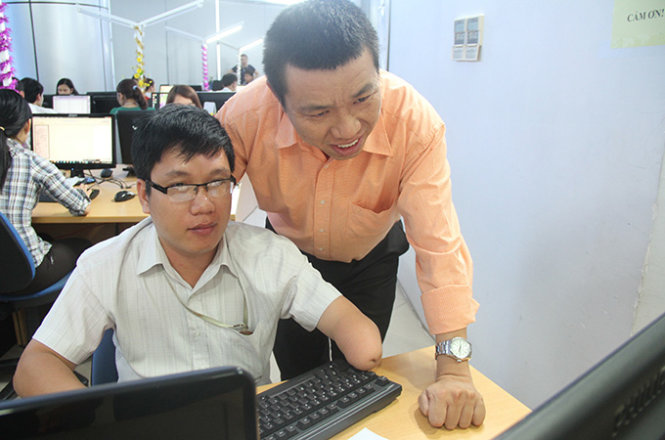 Anh Huy (phải) chỉ bảo kỹ thuật cho nhân viên trong công ty mình - Ảnh: Đ.Cường